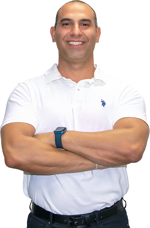 Smiling sports chiropractor, Dr. Roy Nissim, confidently crossing arms in a white polo shirt