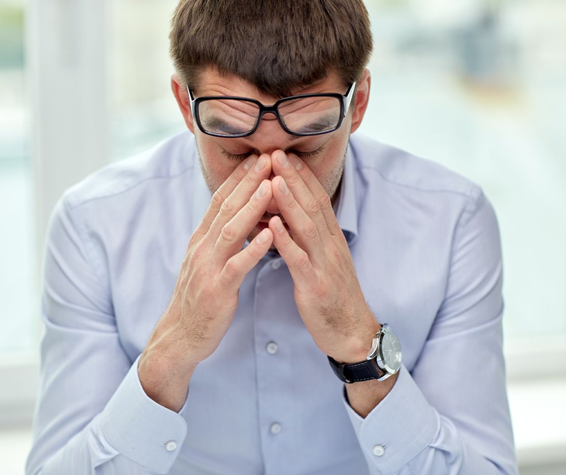 business, people and work concept - tired businessman with eyeglasses in office