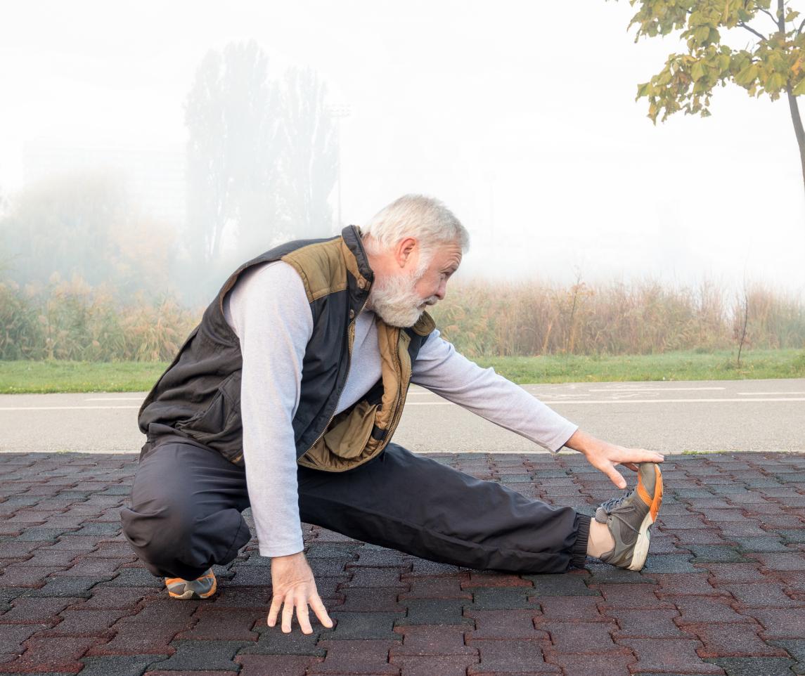 Elderly man doing physical exercise in the morning in park. Take regular breaks.