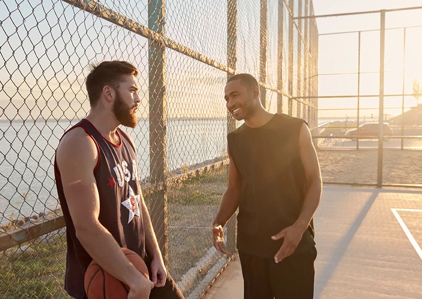 a couple of men discussion something on a basketball court