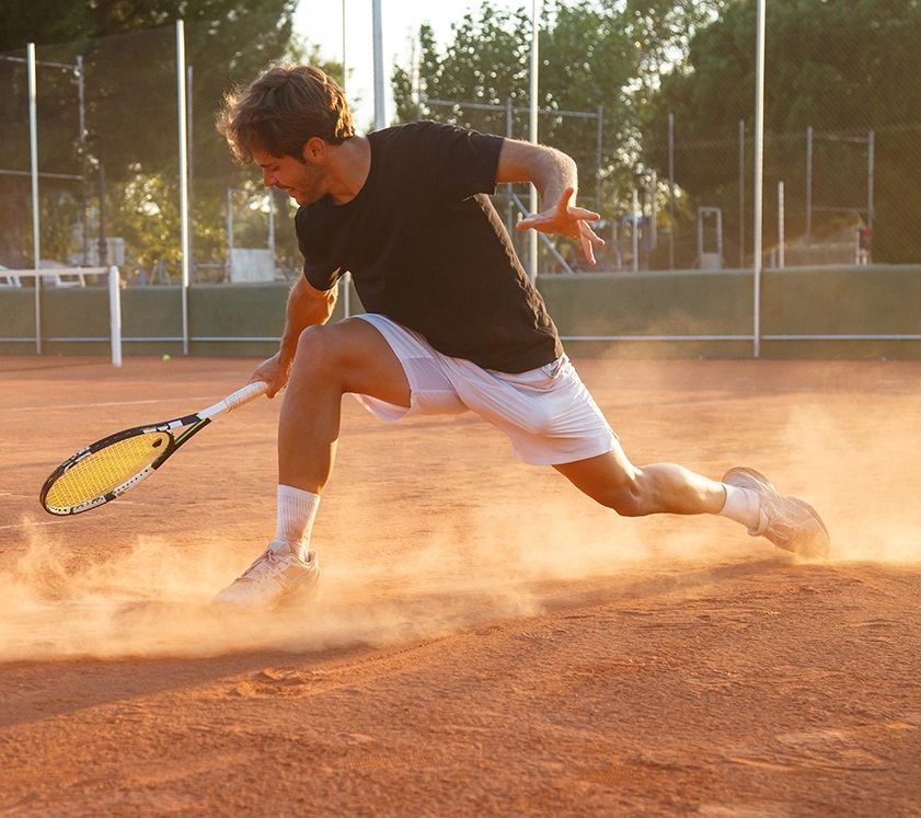 a guy playing tennis on a clay court