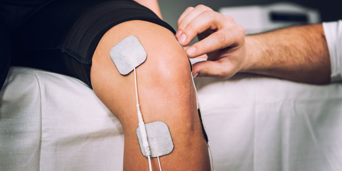 TENS electrodes positioned for knee pain treatment in physical therapy