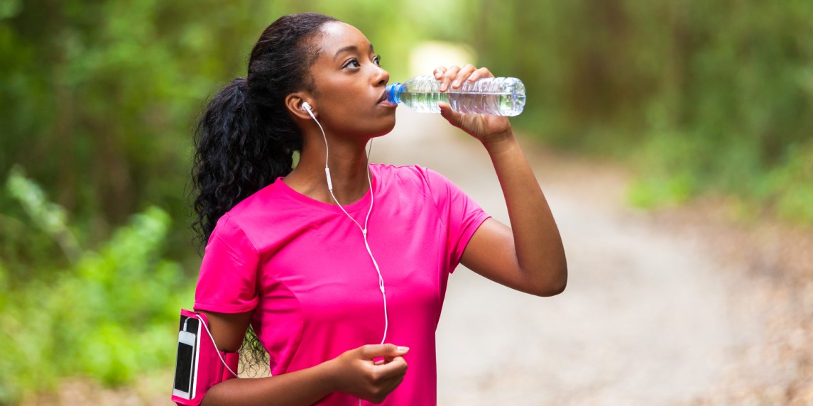Woman jogger drinking water.