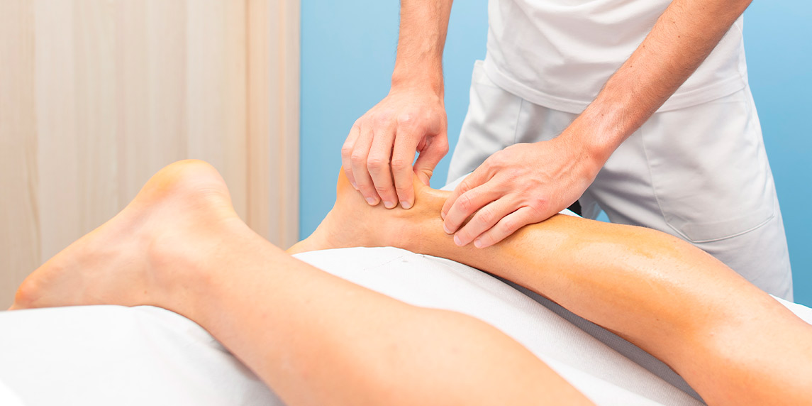 A person receiving a leg massage, highlighting the importance of recovery in sports, especially related to Achilles injuries.