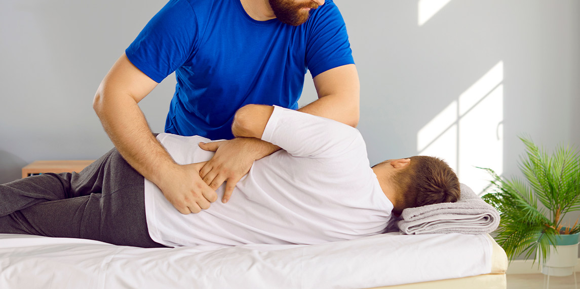 A man receives a back massage from a physical therapist, promoting wellness and comfort in the workplace.