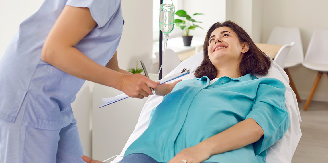 A woman receives a blood pressure check from a nurse, highlighting the importance of health during IV therapy for immune support.