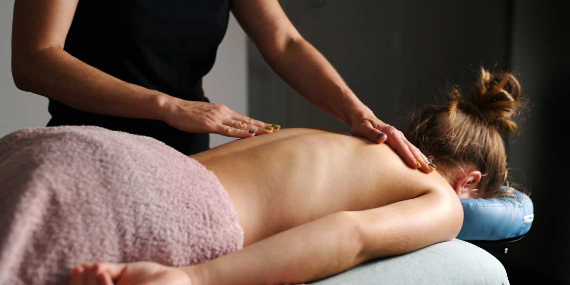 Professional Massage Therapist Doing Back Massage To Young Girl In Spa Salon