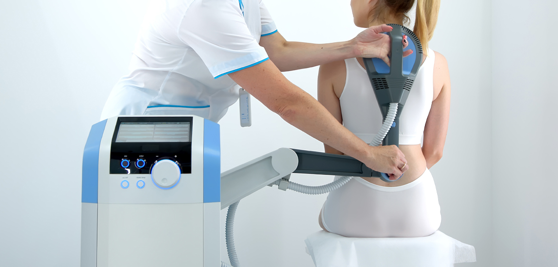 A physiotherapist administers advanced electromagnetic therapy for back pain relief using state-of-the-art equipment. Ideal for showcasing effective pain management and rehabilitation techniques.